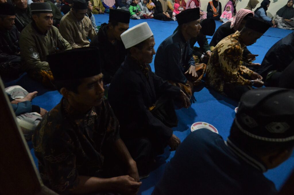 Sekelompok orang duduk di lantai masjid.